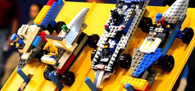 Brick-built derby cars lined up on the yellow race track
